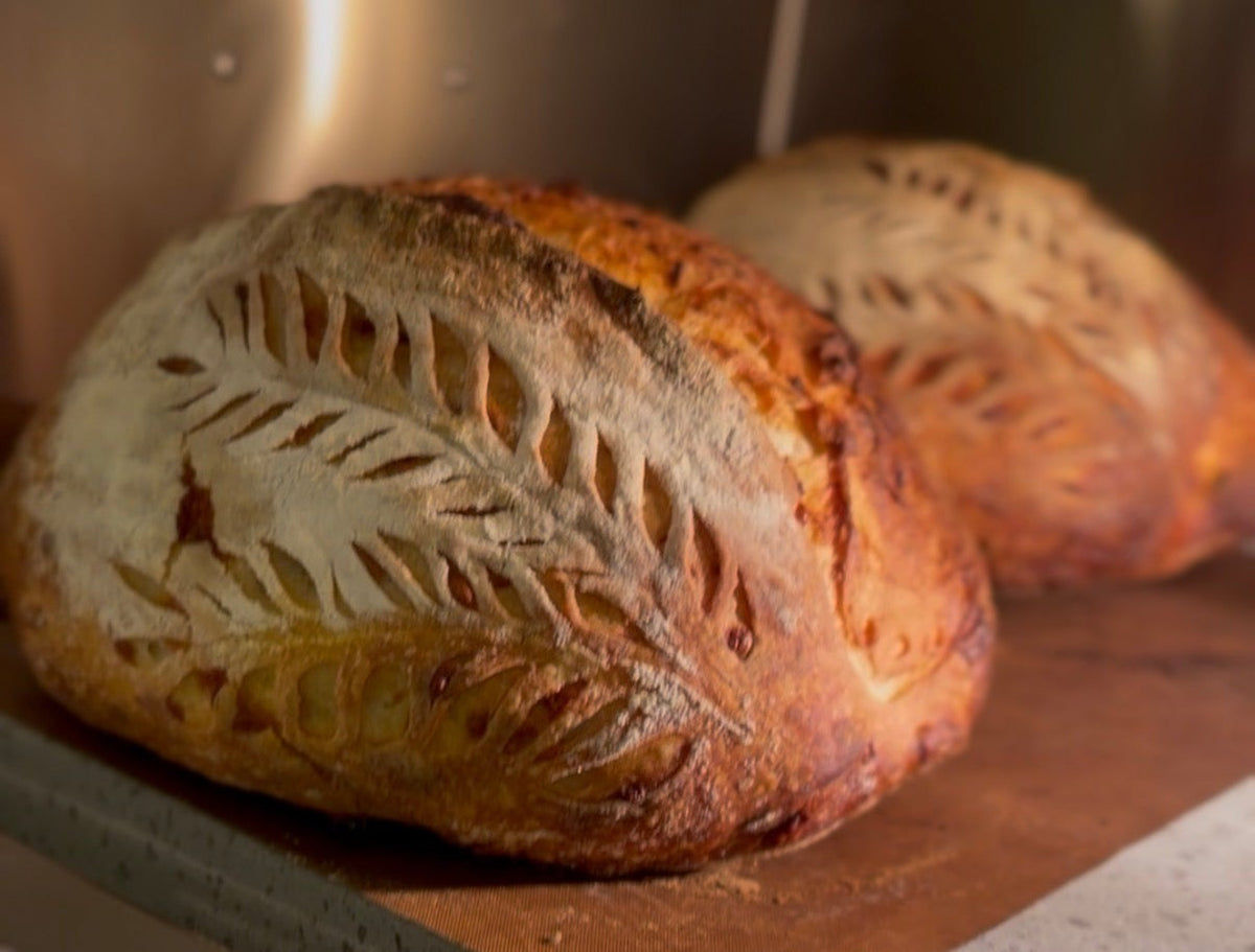 Nybakte surdeigsbrød med vakker scoring – håndlaget av Henrik hos SurdeigMedV